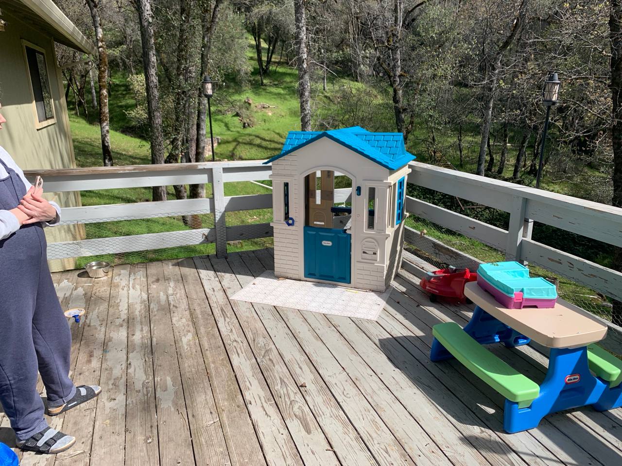 Before: Weathered gray wooden deck with children's play equipment in Placerville