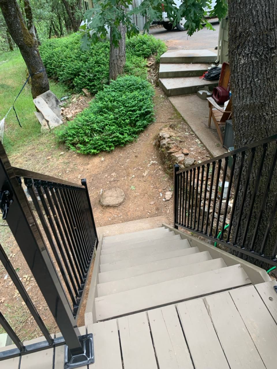 After: New stairs with black metal railing leading to an elevated deck