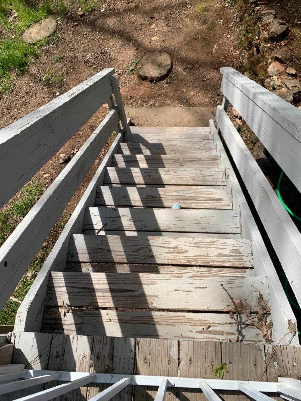 Before: Worn wooden stairs with white-painted railing in Placerville